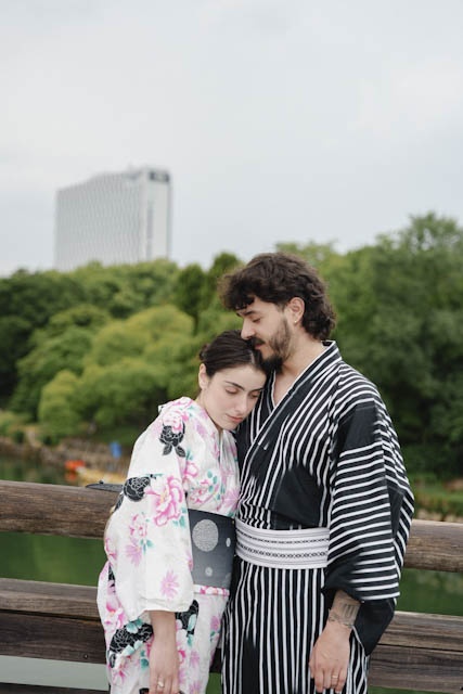 Couple wearing traditional Japanese yukata standing together near a wooden railing
