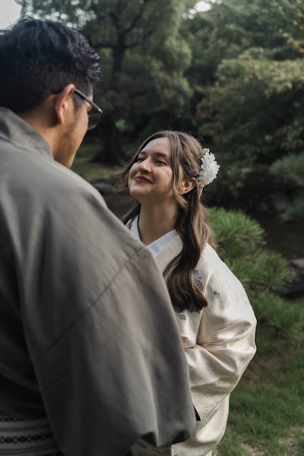 Couple wearing traditional kimono looking at each other in a garden