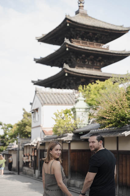 Couple walking on a traditional street with a pagoda in background