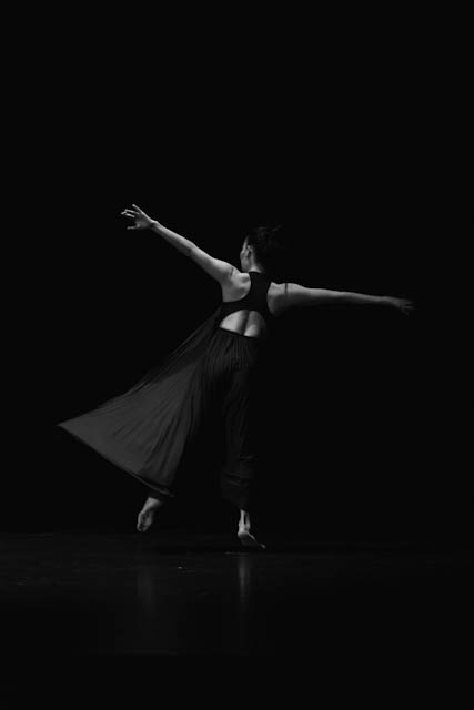 Dancer in flowing skirt performing in black and white