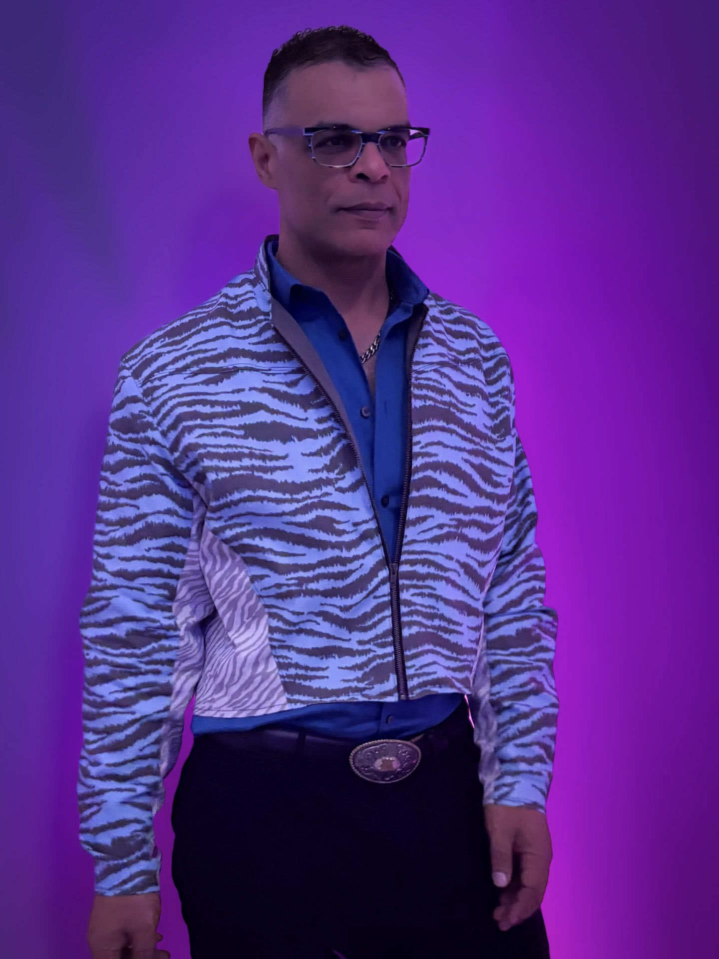 Standing tiger-patterned jacket portrait in purple light.