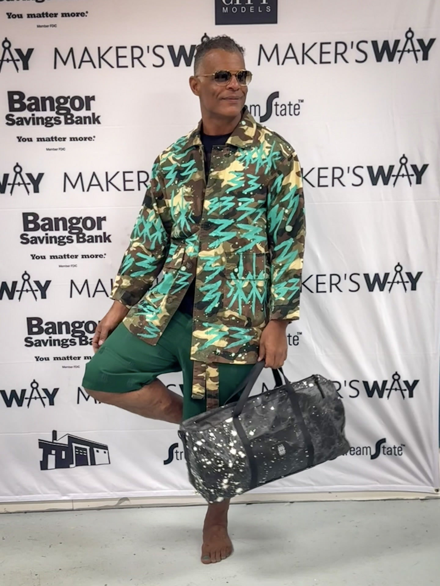 Kristopher wearing a green graphic outfit at Makers Way.