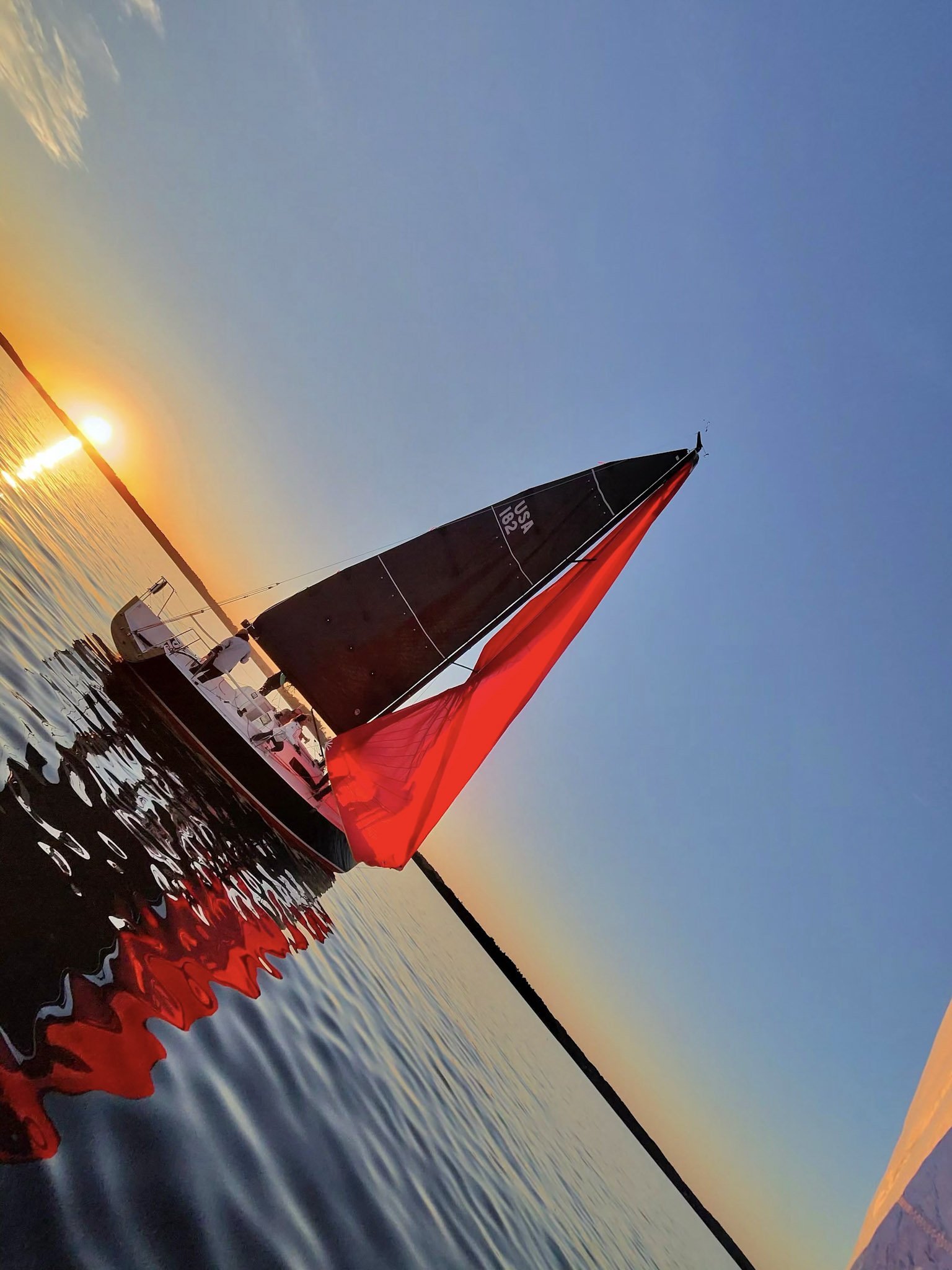 Sailboats near the shore in golden evening light.