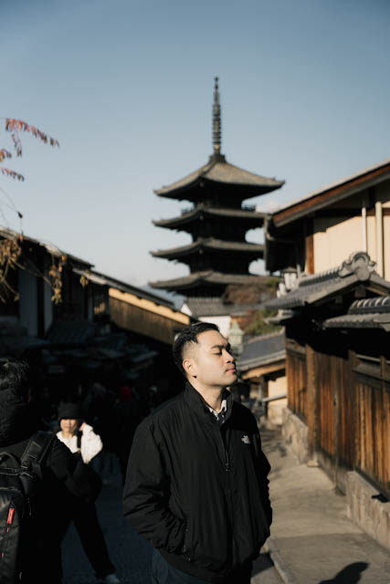 Man standing in traditional Japanese street with pagoda