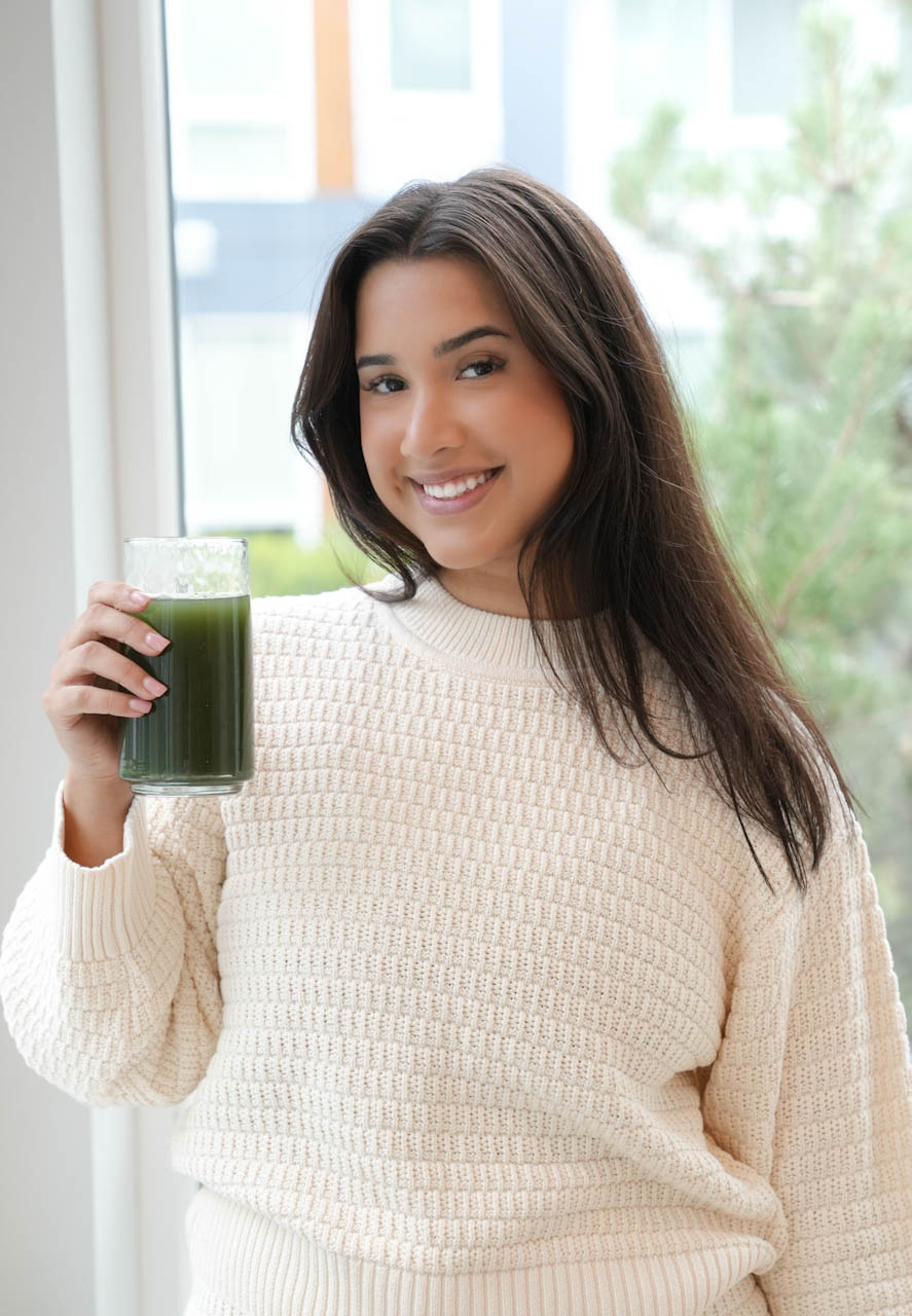 Woman mixing Biome Theory Super Greens in her kitchen